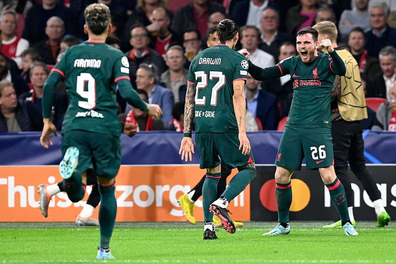 Liverpool's Uruguayan striker Darwin Nunez (C) celebrates scoring his team's second goal with Liverpool's Scottish defender Andrew Robertson (R) during the UEFA Champions League group A football match between Ajax Amsterdam and Liverpool at the Johan Cruijff ArenA in Amsterdam, on 
26 October, 2022