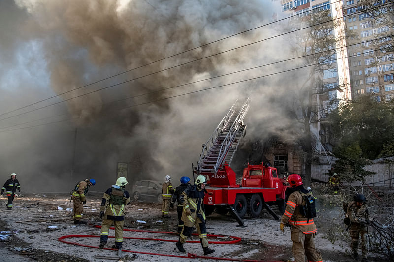 Firefighters help a local woman evacuate from a residential building destroyed by a Russian drone strike, which local authorities consider to be Iranian-made unmanned aerial vehicles (UAVs) Shahed-136, amid Russia's attack on Ukraine, in Kyiv, Ukraine October 17, 2022