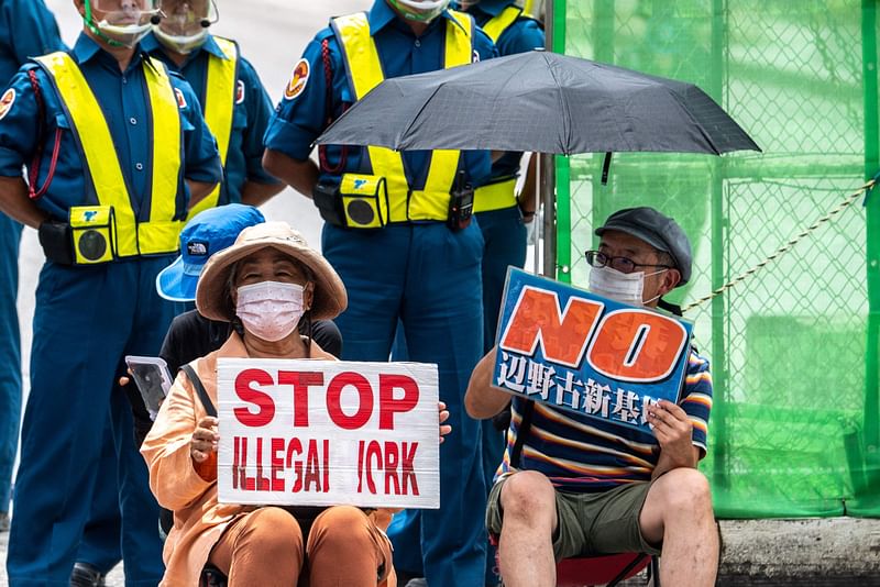 This picture taken on 24 August, 2022 shows anti-base activist Suzuyo Takazato (bottom L) taking part in a protest outside Henoko US base in Nago, Okinawa Prefecture