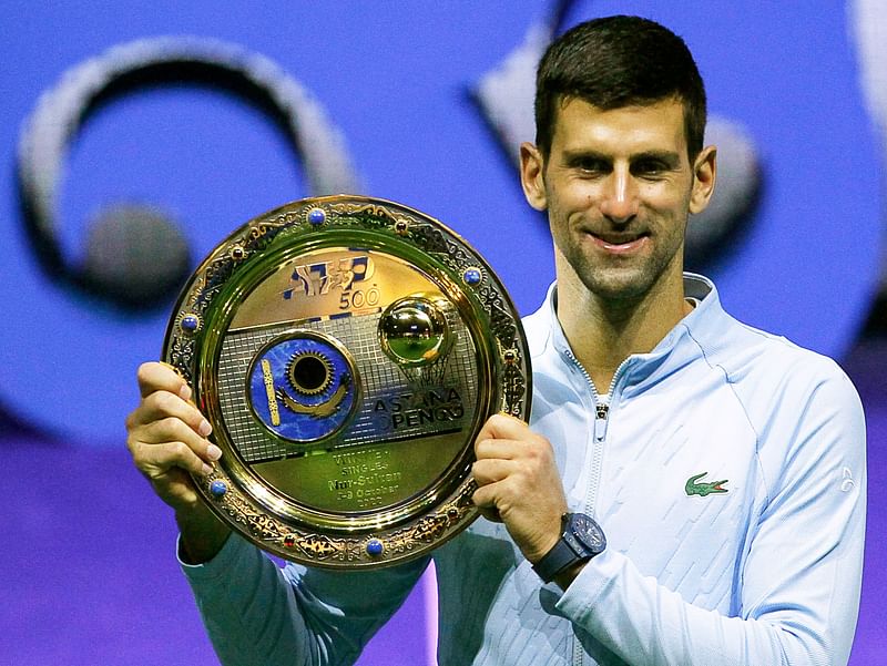 Serbia's Novak Djokovic celebrates with the trophy after defeating Greece's Stefanos Tsitsipas in their men's singles final match at the Astana Open tennis tournament in Astana on 9 October, 2022