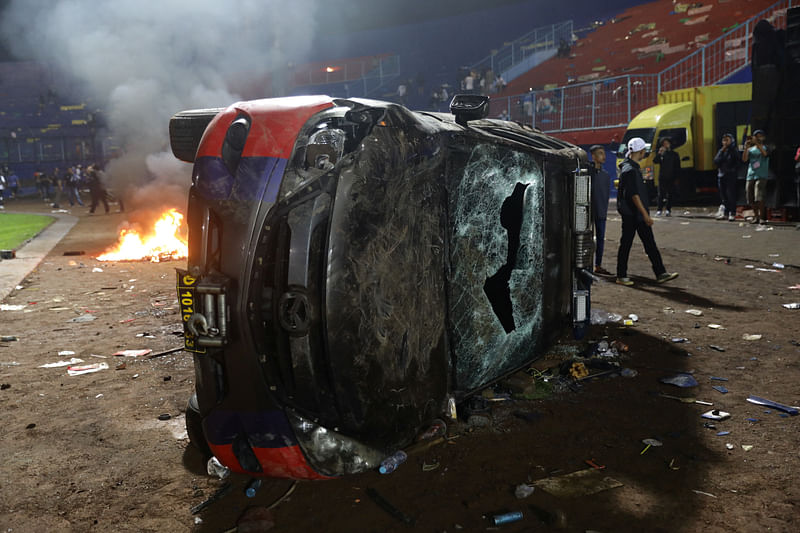 A damaged car is pictured following a riot after the league BRI Liga 1 football match between Arema vs Persebaya at Kanjuruhan Stadium, Malang, East Java province, Indonesia, 2 October, 2022