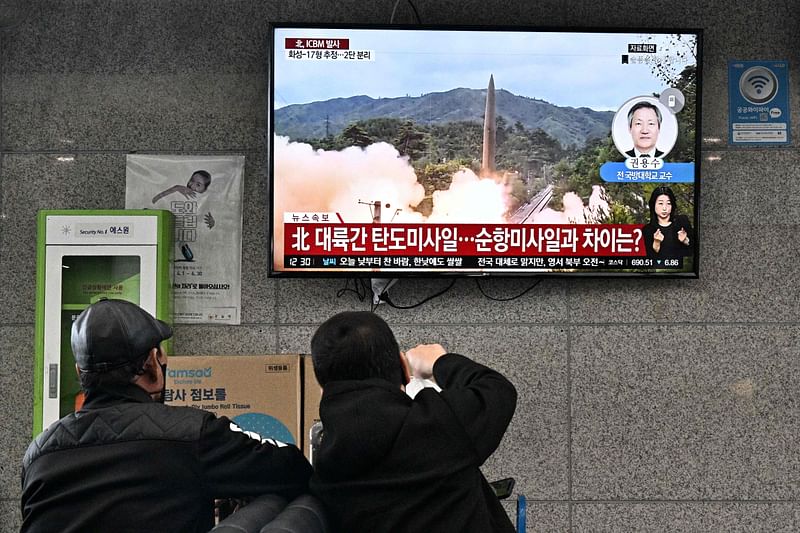 In this file photo taken on 3 November, 2022, visitors watch a news broadcast showing file footage of a North Korean missile test at the ferry terminal of South Korea's eastern island of Ulleungdo, in the East Sea, also known as the Sea of Japan