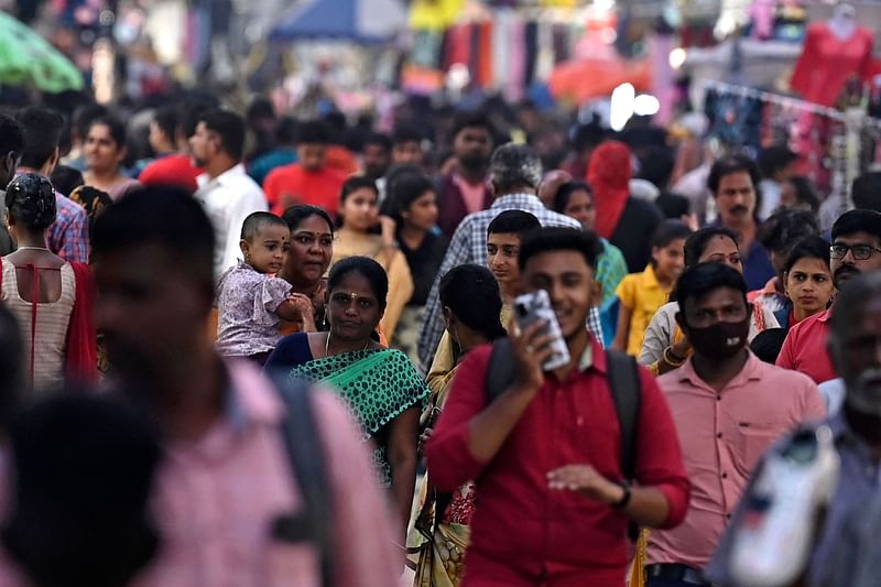 In this photograph taken on 31 October, 2022, people walk through a crowded commercial street in Chennai