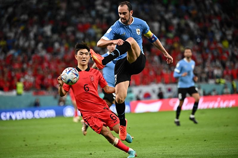 Uruguay's defender Diego Godin shoots the ball past South Korea's midfielder Hwang In-beom during the FIFA World Cup 2022 Group H football match between Uruguay and South Korea at the Education City Stadium in Al-Rayyan, west of Doha on 24 November, 2022