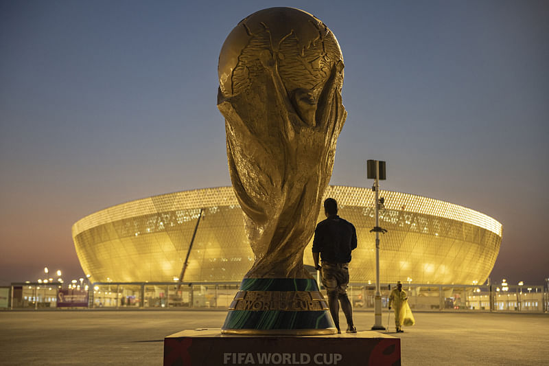 A man with a replica of the World Cup outside Lusail Stadium ahead of the World Cup in Lusial, Qatar on 10 November, 2022