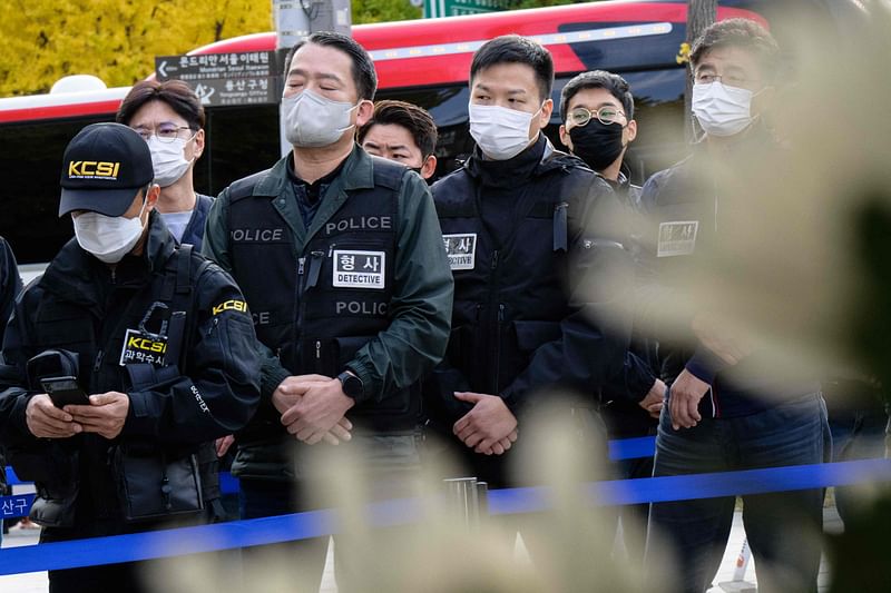 Police line up to pay tribute at a joint memorial altar for victims of the deadly Halloween crowd surge, in Naksopyeong, near the district of Itaewon in Seoul on October 31, 2022