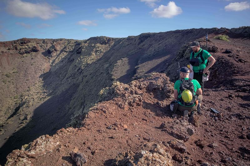 German astronaut Alexander Gerst (L) collects samples on the summit of an ancient volcano during a training program to learn how to explore the Moon and Mars in the Timanfaya National Park in the Canary island of Lanzarote on 10 November, 2022. With its blackened lava fields, craters, and volcanic tubes, Lanzarote's geology can be uncannily similar to that of the Moon and Mars -- so much so that the European Space Agency (ESA) and NASA have for years been sending astronauts to the islands to train.