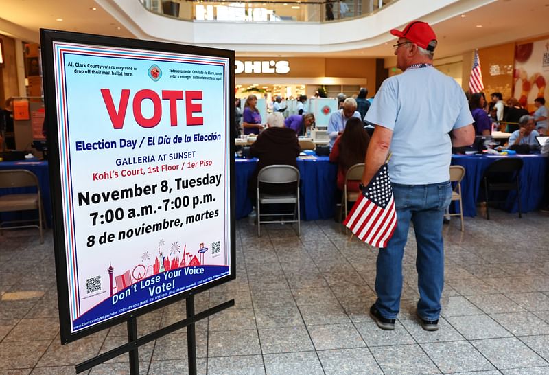 An election worker holds an American flag at a polling place at Galleria at Sunset on 8 November, 2022 in Henderson, Nevada