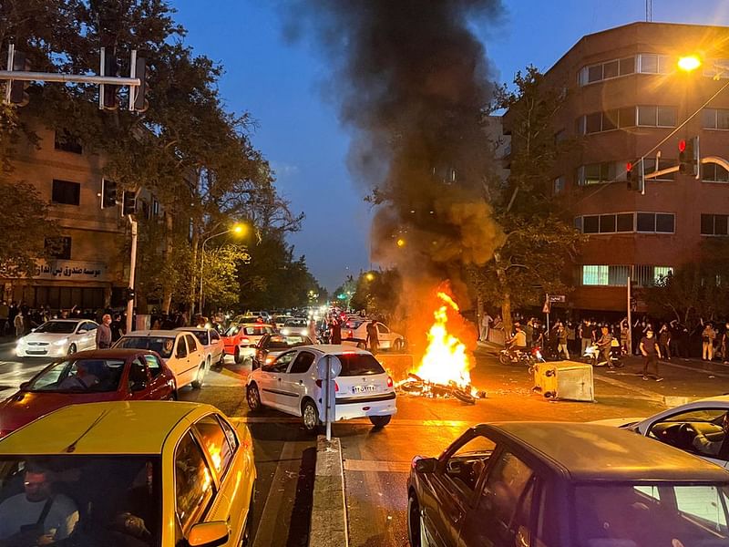 A police motorcycle burns during a protest over the death of Mahsa Amini, a woman who died after being arrested by the Islamic republic's "morality police", in Tehran, Iran on 19 September, 2022.