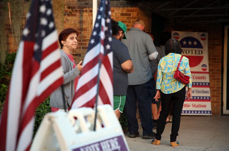 Voters wait in line to cast their ballots in the midterm elections at a polling station in Kissimmee, Florida on 8 November, 2022.