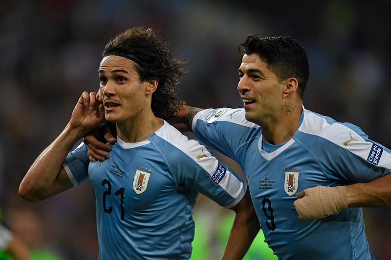 In this file photo taken on 24 June, 2019, Uruguay's Edinson Cavani (L) celebrates with teammate Luis Suarez after scoring against Chile during their Copa America football tournament group match at Maracana Stadium in Rio de Janeiro, Brazil