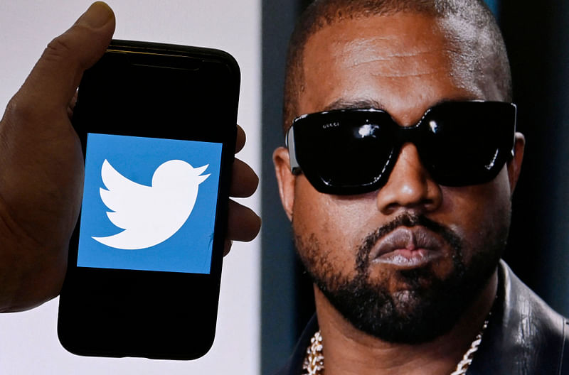 In this file photo illustration, the Twitter logo is displayed on a mobile phone with a photo of Kanye West shown in the background on 28 October, 2022 in Washington, DC.