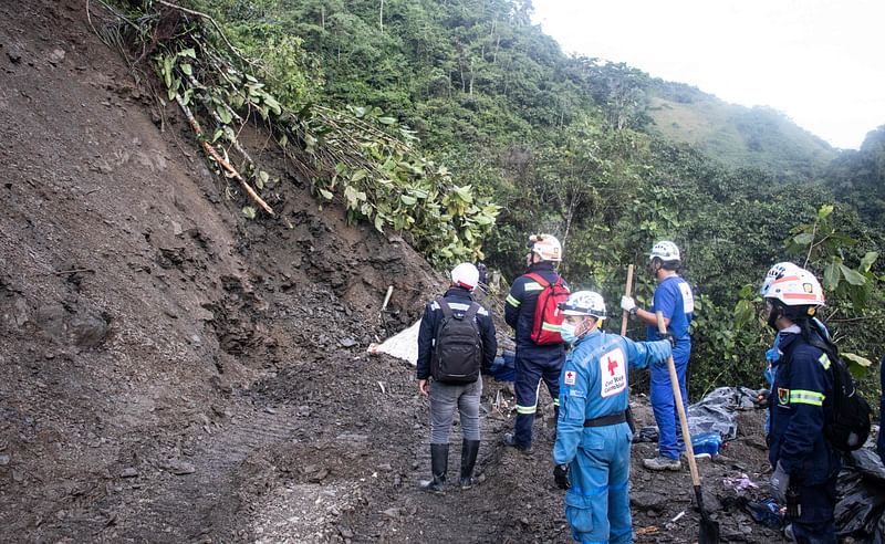 Rescue teams stand next to a dead body after a mountain landslide in the sector El Ruso, Pueblo Rico municipality, in northwestern Bogota, Colombia, on 5 December, 2022