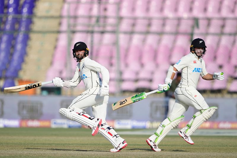 New Zealand's Devon Conway and Tom Latham run between the wickets during the second day of the first Test between Pakistan and New Zealand at the National Stadium in Karachi on 27 December, 2022