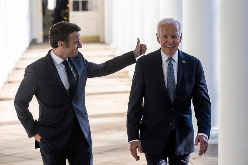 US President Joe Biden and French President Emmanuel Macron walk down the Colonnade at the White House in Washington, DC, on 1 December, 2022