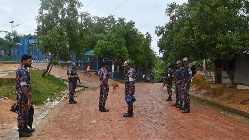 Armed Police Battalion (APBn) personnel stand guard along a road at Kutupalong refugee camp in Ukhiya on 13 August, 2022