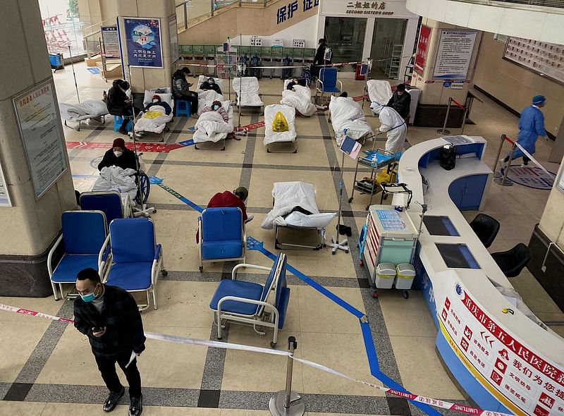 A man stands in front of a cordoned-off area, where Covid-19 coronavirus patients lie on hospital beds, in the lobby of the Chongqing No. 5 People's Hospital in China's southwestern city of Chongqing on 23 December, 2022