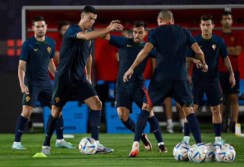 Portugal's forward Cristiano Ronaldo (L) and his teammate Ricardo Horta (C) take part in a training session at the Al Shahaniya SC training site. northwest of Doha on 5 December, 2022