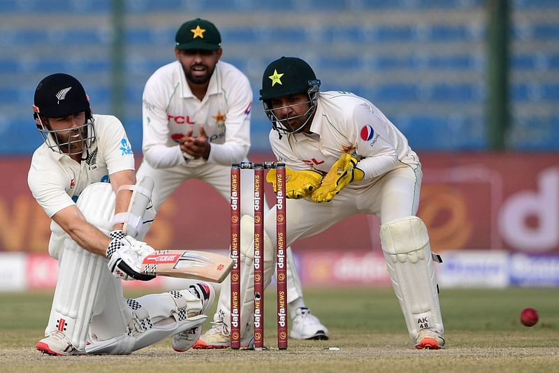 New Zealand's Kane Williamson (L) plays a shot during the fourth day of the first Test match between Pakistan and New Zealand at the National Stadium in Karachi on 29 December, 2022