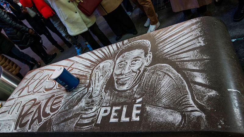 An image of Brazilian football legend Pele drawn with salt as a memorial is seen while people mourn his death at the Pele soccer store in Times Square in the Manhattan borough of New York City, US on 29 December, 2022