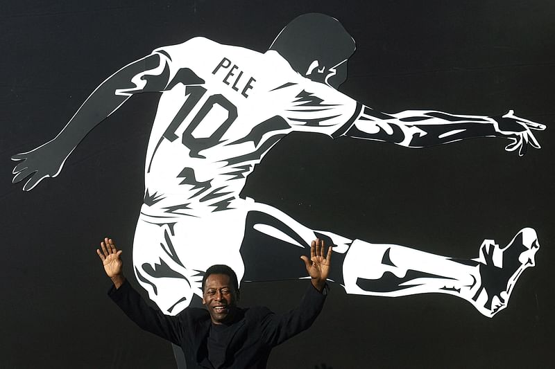 In this file photo taken on 25 June, 2008 Brazilian football legend Pele raises his arms during the opening ceremony of the "Marks of the King" exhibition in Brasilia