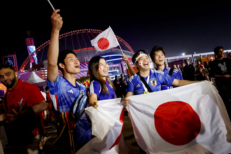 Japan fans celebrate outside the Lusail stadium after Japan defeated Spain and qualified for the knockout stages