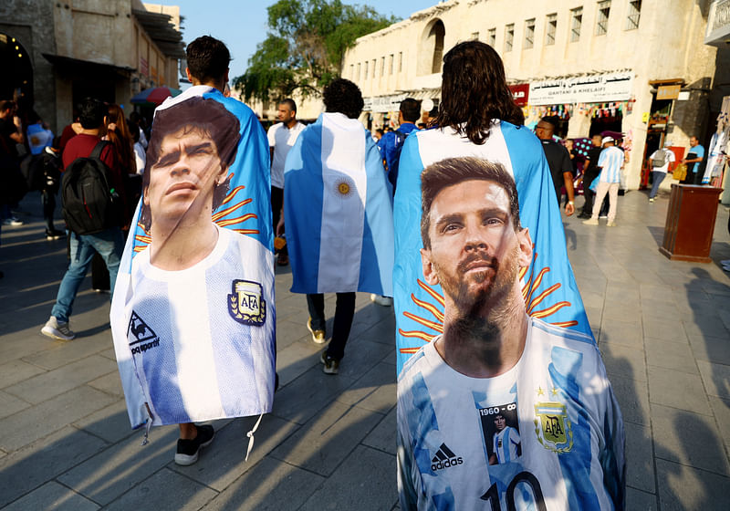 Argentina fans with flags of Lionel Messi and Diego Maradona ahead of the semi-final match of Argentina v Croatia at Souq Waqif in Doha, Qatar on 13 December, 2022