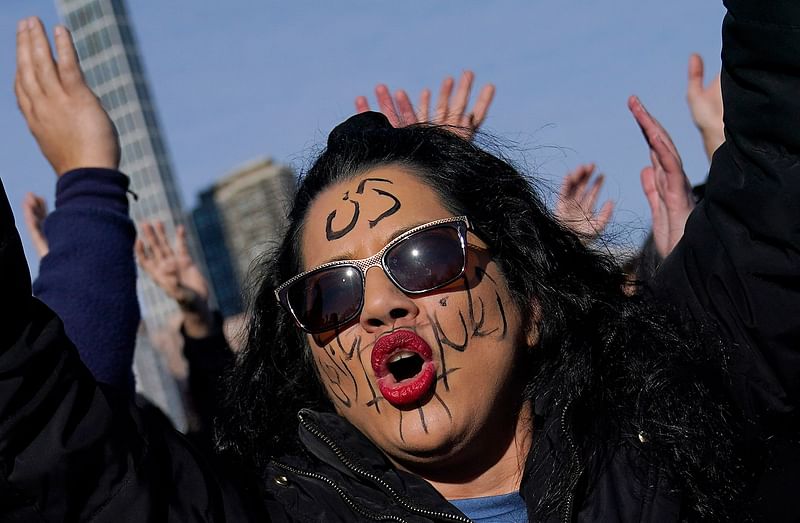 People pose for a photo as artist JR, in partnership with For Freedoms, Vital Voices, and the Woman, Life, Freedom global coalition of Iranian women leaders, holds one of his participatory performances on the lawn of Four Freedoms Park on 4 December, 2022 on Roosevelt Island in New York.