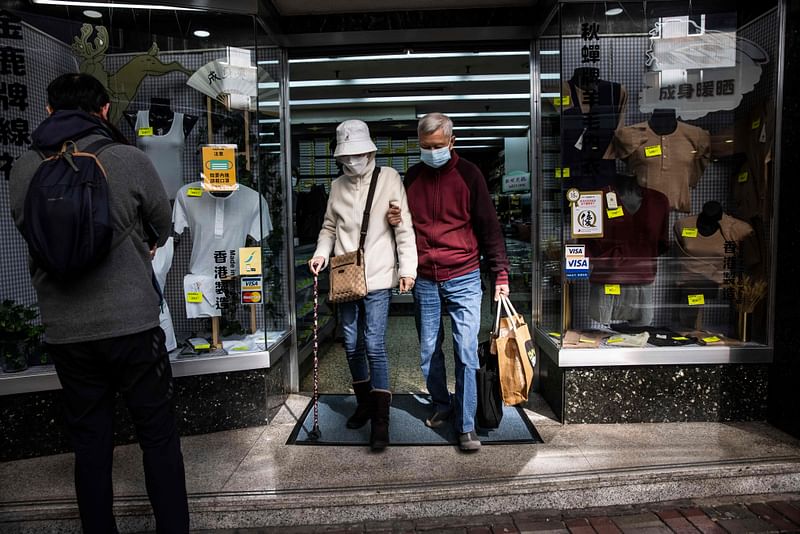 Customers (C) leave a shop known for producing Hong Kong-made undergarments in Hong Kong on December 22, 2022