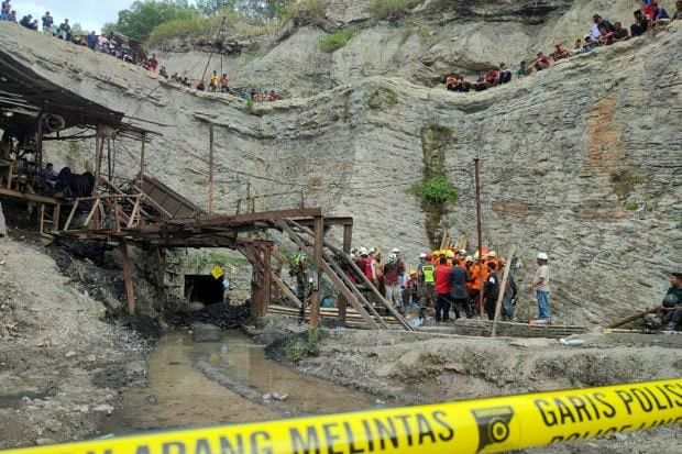 Surviving miners look on as rescue teams evacuate dead and injured victims of a coal mine explosion in Sawahlunto on 9 December 9, 2022.