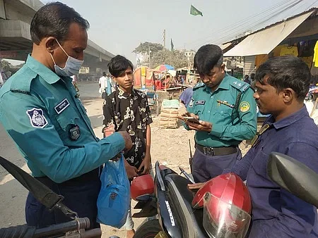 The policemen are checking mobile phones of commuters in the Tongi bridge area in Gazipur on 7 December 2022.