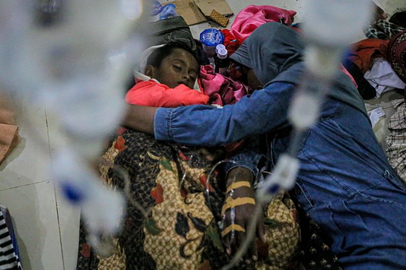 This photo taken on 26 December, 2022 shows a Rohingya woman and child resting at a shelter in the Muara Tiga district in Pidie, Aceh province