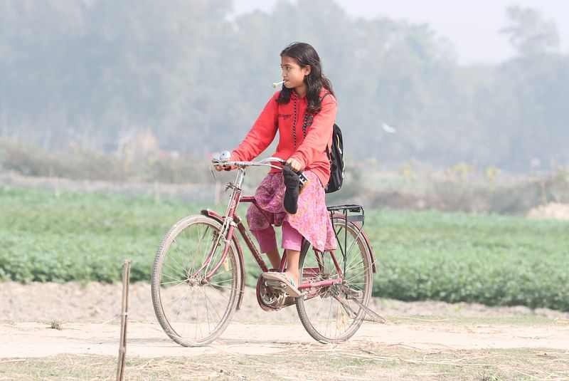 A girl rides bicycle to the home from school. The picture was taken from Ramjibon in Rangpur