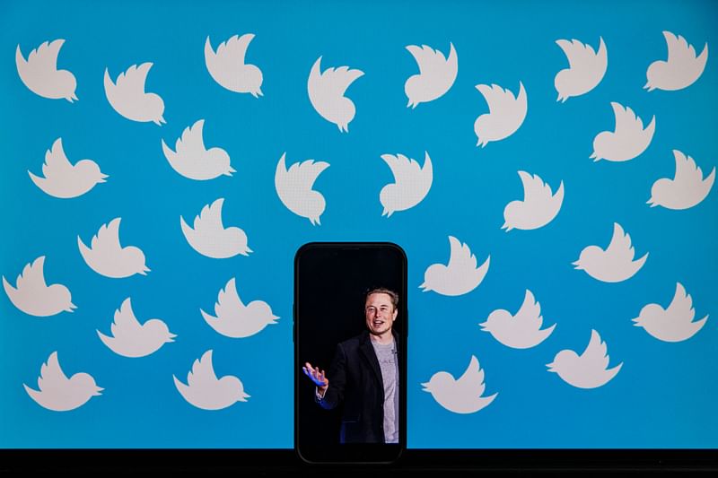 In this file photo taken on 5 August, 2022, an illustration photo shows a cellphone displaying a photo of Elon Musk placed on a computer monitor filled with Twitter logos in Washington, DC. Twitter boss Elon Musk announced in a series of tweets on 21 January, 2023, that the company's subscription service would show less advertising to users, including an ad-free tier.