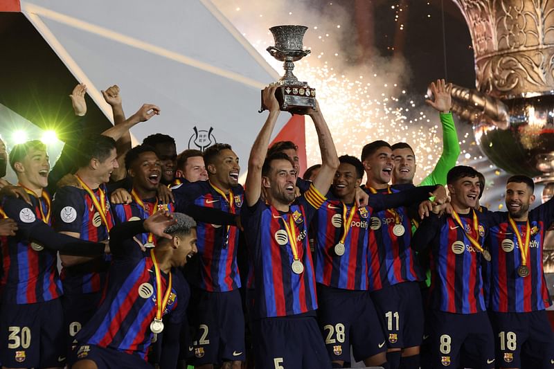 Barcelona's players celebrate on the podium after winning the Spanish Super Cup final football match between Real Madrid CF and FC Barcelona at the King Fahd International Stadium in Riyadh, Saudi Arabia, on 15 January, 2023