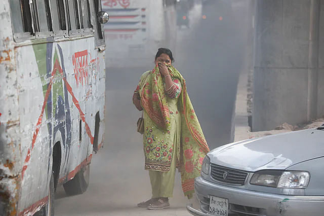 A passer-by breathes in an extremely polluted air in Dhaka