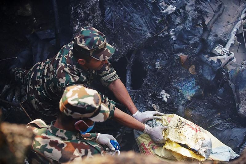 Rescuers inspect the site of a plane crash in Pokhara on 15 January 2023. An aircraft with 72 people on board crashed in Nepal on January 15, Yeti Airlines and a local official said.