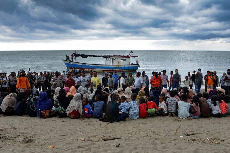 In this file photograph taken on 25 June 25, 2020, evacuated Rohingya from Myanmar sit on the shorelines of Lancok village, in Indonesia's North Aceh Regency, after some 100 including 30 children were rescued from a wooden boat off the coast of Indonesian island of Sumatra. The UN decried on 17 January, 2023, the "alarming" rise in the number of Rohingya refugees lost at sea fleeing their Myanmar homeland or Bangladesh last year, warning more would die without concerted action. More than 3,500 Rohingya attempted sea crossings in 2022, representing a huge increase on the year before, when some 700 people made similar journeys, said UNHCR, the United Nations' refugee agency.