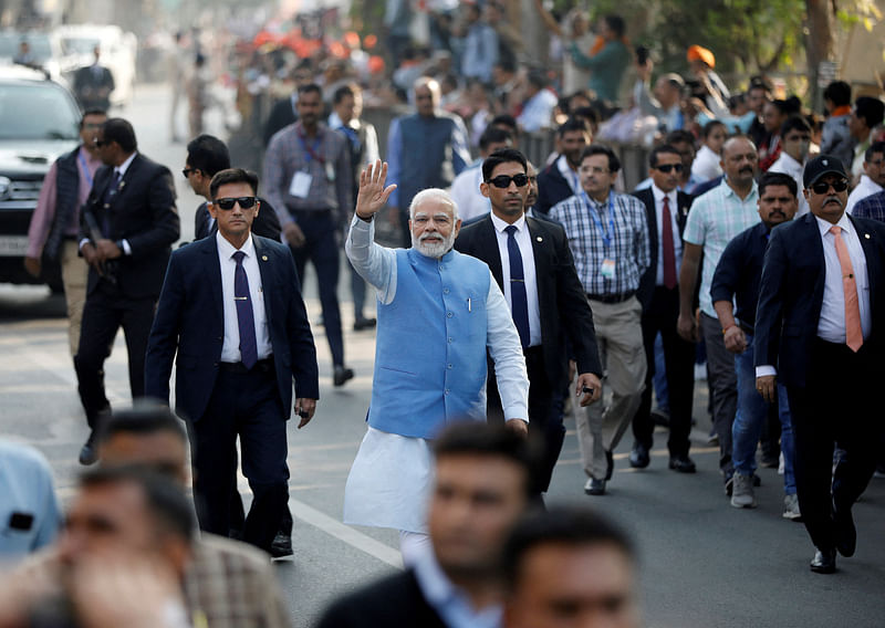 India's prime minister Narendra Modi waves to his supporters as he arrives to cast his vote during the second and last phase of Gujarat state assembly elections in Ahmedabad, India, 5 December 2022.