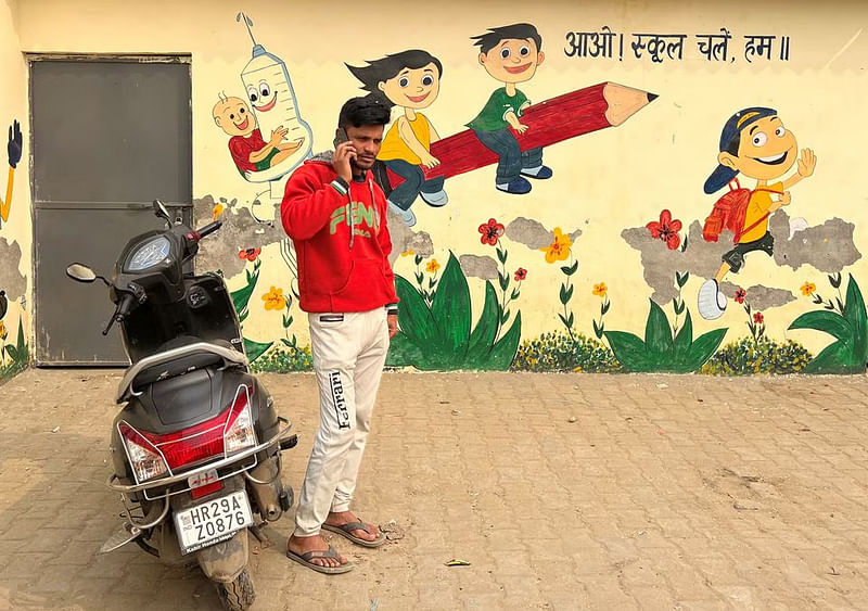 Ravi Verma, 27, an unemployed man who lost his job in November last year, makes queries for a new job on his mobile phone outside a community centre in Faridabad on the outskirts of New Delhi, India, on 13 January, 2023.