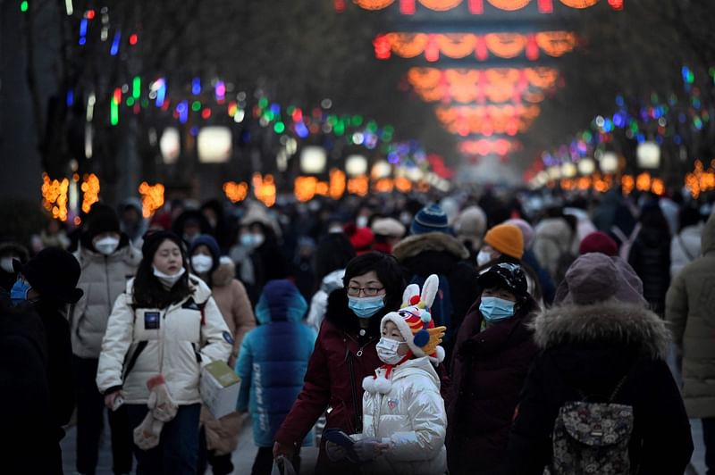 People visit a business street during the Chinese Lunar New Year in Beijing on 25 January, 2023