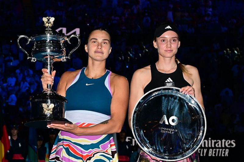 Belarus' Aryna Sabalenka celebrates with the Daphne Akhurst Memorial Cup after defeating Kazakhstan's Elena Rybakina (R) in the women's singles final match on day thirteen of the Australian Open tennis tournament in Melbourne on 28 January, 2023