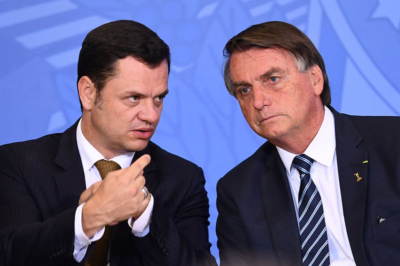 In this file photo taken on 27 June, 2022, Brazilian President Jair Bolsonaro (L) and his Minister of Justice Anderson Torres talk during an event to present the new national ID and passport at Planalto Palace in Brasilia