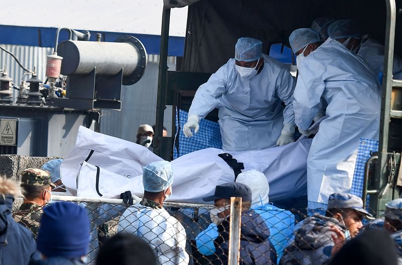 Nepal's army and volunteers carry the body of a victim who died in a plane crash in Pokhara on 17 January, 2023