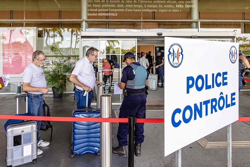 This file photo taken on October 14, 2022, shows a member of the PAF (French Air and Border Police) controlling passengers at the entrance of Felix Eboue international airport in Cayenne, French Guiana