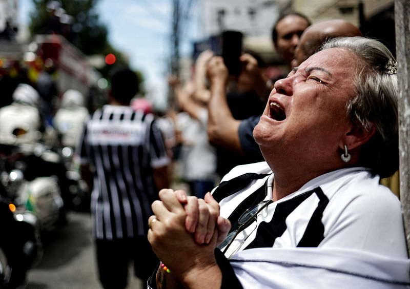 A mourner reacts as Brazilian football legend Pele is transported by the fire department, from his former club Santos' Vila Belmiro stadium in Santos, Sao Paulo in Brazil on 3 January, 2022