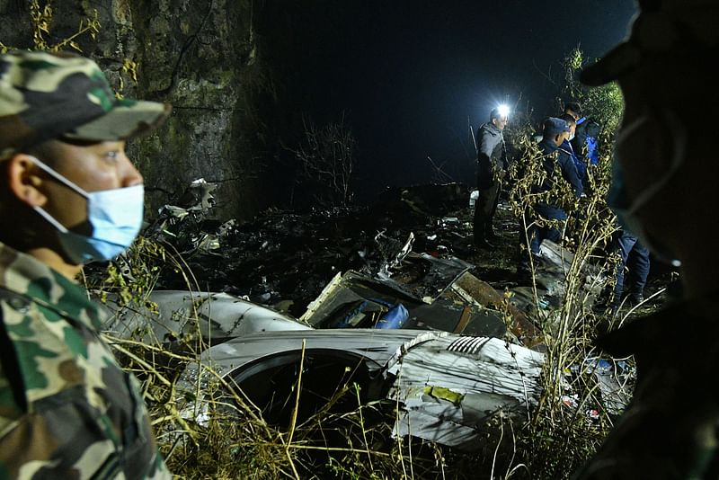 Rescuers inspect the wreckage at the site of a plane crash in Pokhara on 15 January, 2023