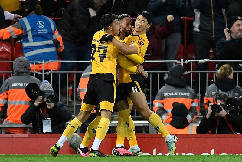 Wolverhampton Wanderers' South Korean striker Hwang Hee-chan (R) celebrates scoring his team's second goal with teammates during the English FA Cup third round football match between Liverpool and Wolverhampton Wanderers at Anfield in Liverpool, north-west England on 7 January, 2023