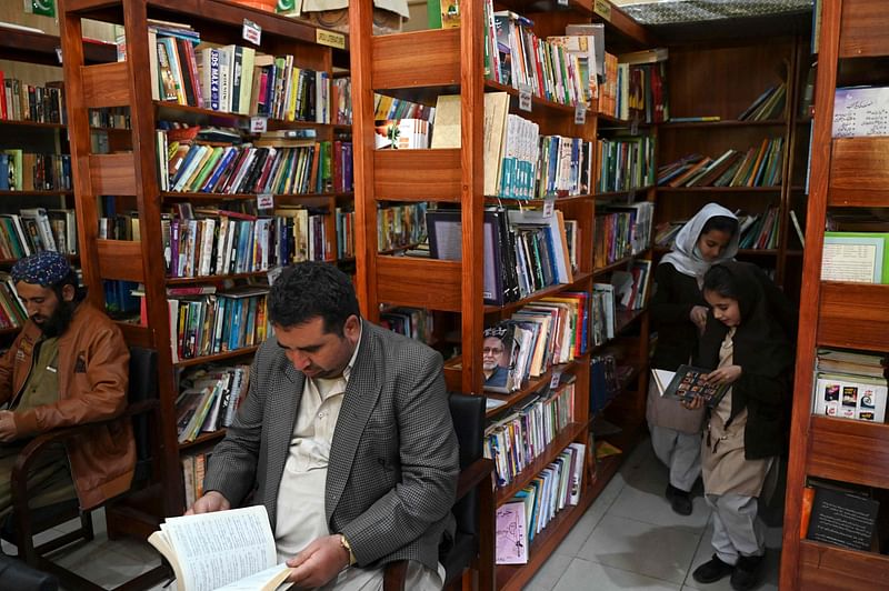 In this photograph taken on 14 December, 2022, people read books inside the Darra Adam Khel Library in Darra Adamkhel town