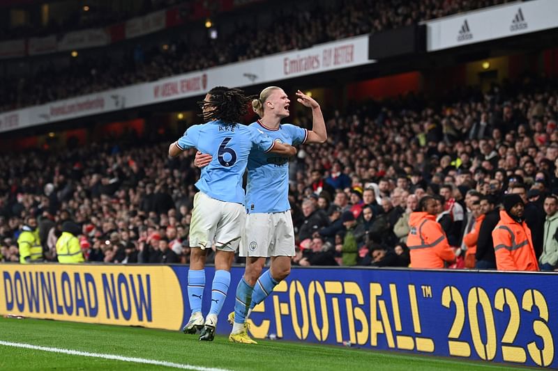 Manchester City's Norwegian striker Erling Haaland (R) celebrates with teammates after scoring his team third goal during the English Premier League football match between Arsenal and Manchester City at the Emirates Stadium in London on 15 February, 2023